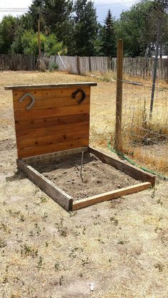 a wooden bed frame sitting in the middle of a field