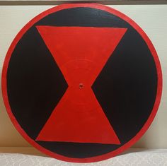 a red, black and white circular sign on a wall