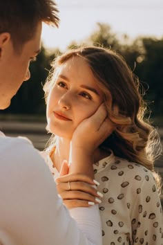 a man and woman standing next to each other with their hands on their chins