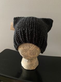 a knitted cat hat sitting on top of a mannequin's head