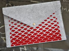 an envelope with red and white fish scales on the front is sitting on a piece of paper