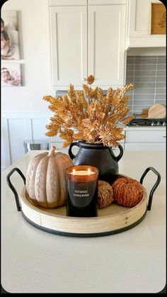 a candle is sitting on top of a tray with some pumpkins and other decorations