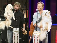 two men are holding dogs on stage at a dog show and one is singing into a microphone