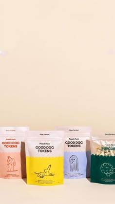 five bags of food sitting on top of a table next to each other in front of a white wall