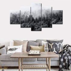 a living room with a couch, coffee table and paintings on the wall in black and white