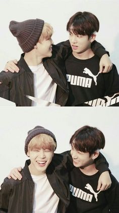 two young men are hugging each other while wearing black sweaters and beanie hats