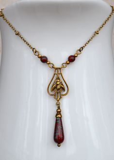 "VINTAGE ELEMENTS Unique Jewellery, Handmade from Vintage Inspired, Original Designs. Art Nouveau, Art Deco Style, antiqued Brass Bee Necklace,  with mottled Red Picasso Czech glass drop. This Necklace has a fine antiqued brass Satellite chain and measures 17\" (43cm) plus a 3\" (7.5cm) extender Chain." Fleurs Art Nouveau, Nouveau Flowers, Festoon Necklace, Art Nouveau Necklaces, Art Nouveau Antiques, Art Nouveau Flowers, Vintage Elements, Bee Necklace, Art Nouveau Style