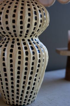 a vase sitting on top of a table next to a chair and other items in the background