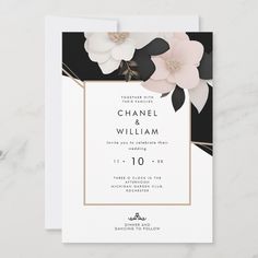 the black and white floral wedding card is displayed on a marble surface with gold accents