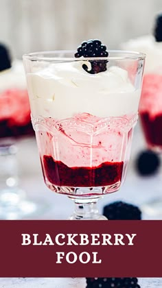 two glasses filled with dessert sitting on top of a table next to berries and spoons