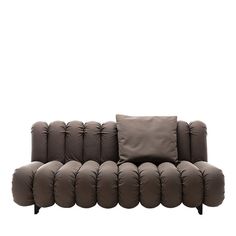 a brown couch with many pillows on it's back and side ends, against a white background