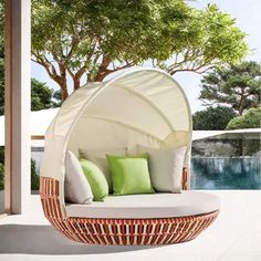 an outdoor day bed with green pillows on it