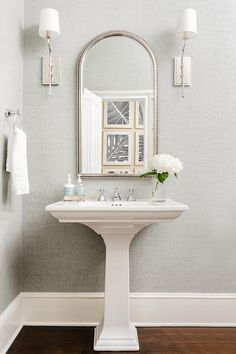 a white pedestal sink sitting under a mirror