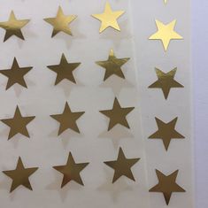 gold stars on white paper are arranged in rows