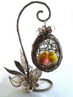 two small birds in a birdcage on a white surface