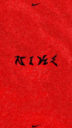 the word nike written in black ink on a red surface with two birds flying overhead