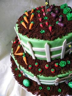 a three tiered cake with carrots and grass on the top is decorated in green icing