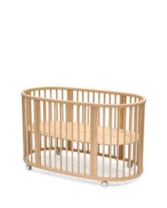 a wooden baby crib with wheels on it