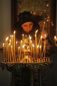 a woman lighting candles in a church