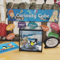 the curiosity cube is on display in front of other children's books and toys