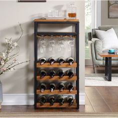 a wine rack with many bottles and glasses on it next to a couch in a living room