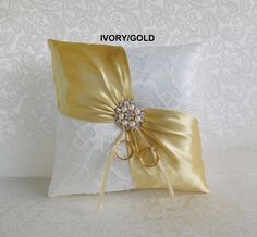 a decorative pillow with a gold bow on the front and white lace around the back