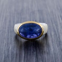 This ring is one of a kind fully made of 925 sterling silver with high quality craftsmanship.  The band which is main highlight of the ring , as its has a matte scratched design band which is done very professionally and takes time. The collet is of pure solid gold vermeil which gives ring a two tone look. Gemstone: Natural Tanzanite AAA quality 10 carat / 11mm x 15mm Facts About Vermeil Jewelry: Is gold vermeil good quality? After solid gold, gold vermeil is the highest quality type of gold ton Timeless Silver Tanzanite Rings, Timeless Silver Tanzanite Jewelry, Modern Tanzanite Gemstone Ring, Luxury Handmade Sterling Silver Sapphire Ring, Timeless Tanzanite Rings For Gifts, Timeless Tanzanite Rings As Gift, Handmade Sapphire Ring For Formal Occasions, Polished Tanzanite Sapphire Ring, Tanzanite Rings With Polished Finish For Anniversary