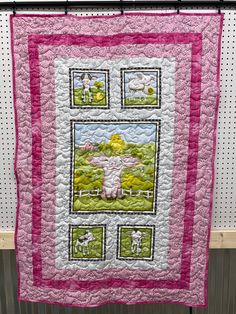 a pink and white quilt with sheep on it