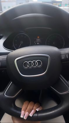 a woman is sitting behind the wheel of a car with her hands on the steering wheel