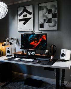 a computer desk with two monitors and speakers on it in a home office area,