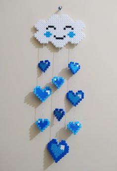 a blue and white cloud with hearts hanging from it's sides on a wall