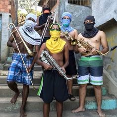 some people are standing on the steps with musical instruments in their hands and wearing bandanas