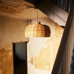 a light fixture hanging from the ceiling in a room with peeling paint on the walls