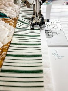 the sewing machine is on top of the quilting material that has been sewn