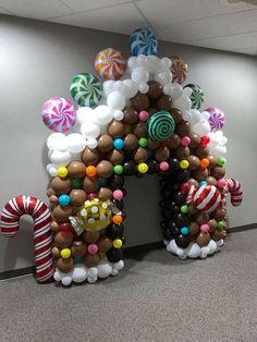 an arch made out of balloons with candy canes and lollipops on it