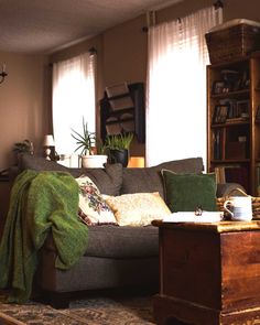 a living room with a couch, coffee table and bookshelf in the corner