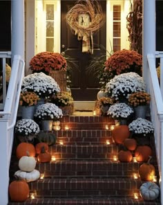 the front porch is decorated with pumpkins and mumins