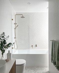 a bathroom with a white tub, toilet and sink