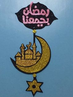 the arabic word is written in pink and gold on top of a crescent with an umbrella