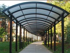 the walkway is lined with black poles and white awnings on either side of it