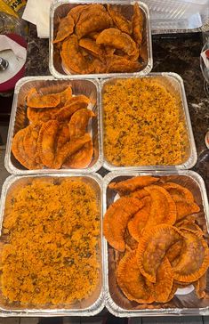 six trays filled with baked potato chips on top of a kitchen counter next to other food items