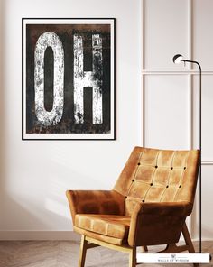 a brown chair sitting in front of a white wall with the word oh on it