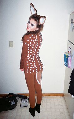 a woman in a deer costume standing next to a refrigerator