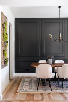 a dining room with black cabinets and white chairs