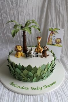 a baby shower cake decorated with animals and palm trees