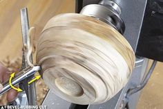 a person working on a piece of wood with a metal object in front of him