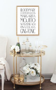 a gold bar cart with wine glasses and flowers