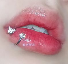 a woman's lips are covered with glitter and has a ring on her lip