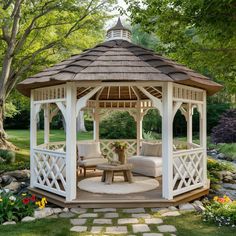 a white gazebo sitting on top of a lush green field