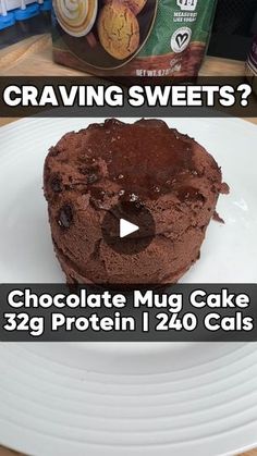 a chocolate mug cake sitting on top of a white plate next to a bag of cookies